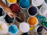 Open paint buckets in many colors seen from above